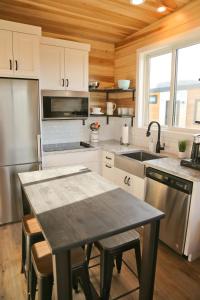 a kitchen with a table and a stainless steel appliance at Escalante Escapes Prickly Pear- Bunk Escape in Escalante