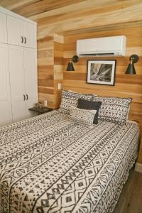 a bedroom with a bed with a black and white comforter at Escalante Escapes Prickly Pear- Bunk Escape in Escalante