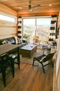 uma sala de estar com um sofá, uma mesa e cadeiras em Escalante Escapes Tumble Weed- Bunk Escape em Escalante