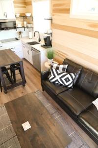 a living room with a leather couch and a kitchen at Escalante Escapes Tumble Weed- Bunk Escape in Escalante