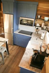 a kitchen with blue cabinets and a stainless steel refrigerator at Escalante Escapes Star Lily- Bunk Escape in Escalante