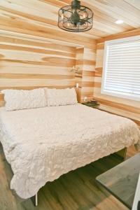 a bedroom with a white bed in a wooden wall at Escalante Escapes Wild Rose- King Escape in Escalante