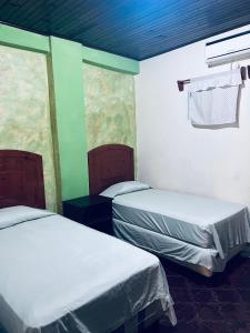a room with two beds in a room at Los Guacamayos La Ceiba in La Ceiba