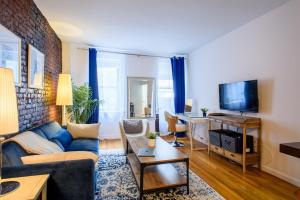 Una sala de estar con un sofá y un televisor. en 350-1A Gramercy New 1BR Sleeps4 Newly Furnished, en Nueva York