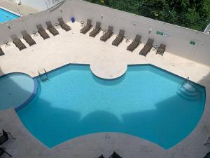 una vista aérea de una piscina con sillas en Apartamentos Classy Reef alado de la playa en San Andrés