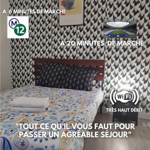 Cartel de un dormitorio con cama y pared en Cosy T2 à 5 minutes de Metro 12-Proche Paris-Stade de France, en Aubervilliers