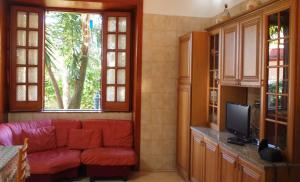 ein Wohnzimmer mit einem roten Sofa und einem TV in der Unterkunft Villa Palmira in Quadrelle