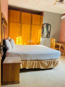 1 dormitorio con 1 cama grande y armarios de madera en Heavens Gate, en Accra
