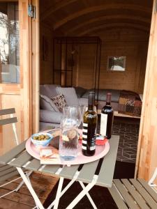 duas garrafas de vinho estão sentadas numa mesa em Cosy Shepherds hut Between Maple and Hawthorn em Mountshannon