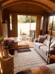 uma sala de estar com um sofá e uma mesa em Cosy Shepherds hut Between Maple and Hawthorn em Mountshannon
