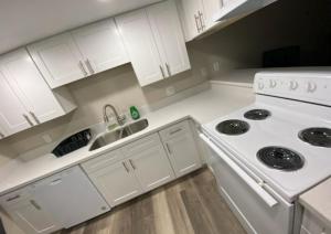 a white kitchen with a stove and a sink at Private room. 5 mins from Freemont. 10 mins from strip in Las Vegas