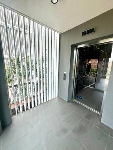 un corridoio vuoto con porta scorrevole in vetro che conduce a un balcone. di Luxe Modern Randwick Abode with elevator a Sydney