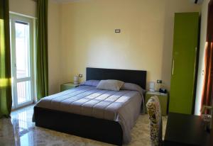 a bedroom with a bed in a room with green walls at B&B La Stazione in Acquaviva delle Fonti