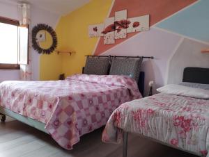 Appartamento in Garfagnana في كاستيلنيوفو دي غارفانيانا: سريرين في غرفة نوم مع ملاءات وردية وبيضاء