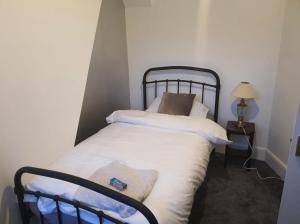 niewielka sypialnia z łóżkiem z białą pościelą w obiekcie Home for all w mieście Wincobank