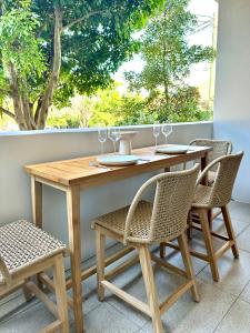 a wooden table with two chairs and a table with wine glasses at Luxury 1 BR Apartment in Randwick- Walk to hospital UNSW Dining W parking and lift and AC in Sydney