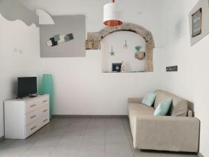 a living room with a couch and a tv at La Corte di Aretusa in Siracusa