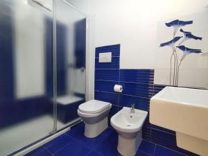 シラクーサにあるLa Corte di Aretusaの青と白のバスルーム(トイレ、シンク付)