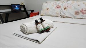 two bottles of wine on a bed with a towel at Hostel Hay's 1 Aeroporto Boa Viagem in Recife