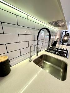 a kitchen with a sink and a stove at Luxe Modern Randwick Abode with elevator in Sydney