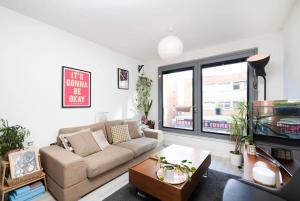 a living room with a couch and a table at Chic 1BR London Flat with Balcony and Garden Access in London