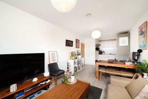 a living room with a large flat screen tv at Chic 1BR London Flat with Balcony and Garden Access in London