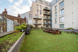 a courtyard with benches and tables in a building at Chic 1BR London Flat with Balcony and Garden Access in London