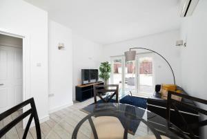 a living room with a glass table and a mirror at 2BR 2Baths ground floor garden apartment in Kingston upon Thames