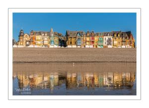 a group of buildings are reflected in the water at appartement rénové et lumineux a mers les bains au dessus d'un ancien commerce mersois en duplex pour 4 personnes pour du repos, des vacances ou pour le travail in Mers-les-Bains