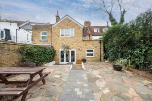 a stone patio in front of a house at 2BR 2Baths ground floor garden apartment in Kingston upon Thames