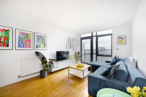 a living room with a blue couch and a tv at Cozy and modern 1BR flat in Enfield in Enfield