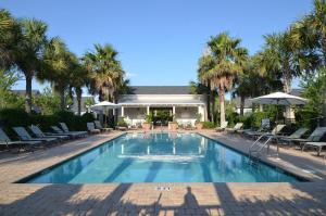 a swimming pool with chairs and umbrellas in front of a house at Bungalos 2441 in Destin