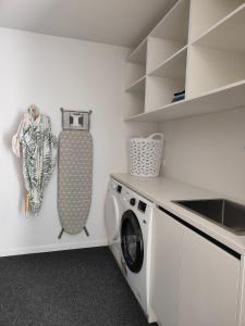 a laundry room with a washer and a washing machine at Tranquil Bamboo Oasis in Christchurch