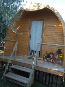 uma cabana de madeira com um alpendre e uma bicicleta no alpendre em Casinha do Melro em Ancião