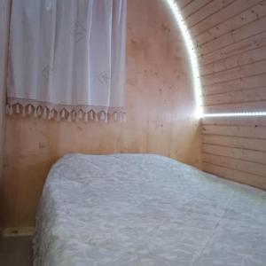 um quarto com uma cama e uma janela com um lençol branco em Casinha do Melro em Ancião