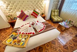 a hotel room with a bed with a tray of food at Hotel Machupicchu Adventure in Machu Picchu