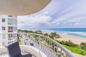 a balcony with two chairs and the beach at Olympus Beachfront Apartments in Gold Coast