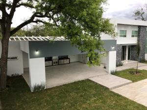 ein weißes Haus mit einem Innenhof mit einem Baum in der Unterkunft Quinta Felinos in Allende