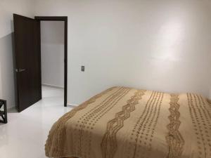 ein Schlafzimmer mit einem Bett mit einer braunen Tagesdecke in der Unterkunft Quinta Felinos in Allende
