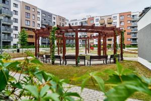 a gazebo with benches in a park with buildings at Apartment Swistackiego with FREE GARAGE in Wrocław