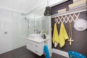 une salle de bain avec un lavabo et un miroir dans l'établissement Casuarina Cabana Beach House, à Casuarina 12 autres photos
