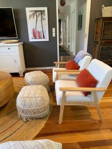 un salon avec deux chaises et une télévision dans l'établissement Casuarina Cabana Beach House, à Casuarina