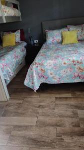 Schlafzimmer mit einem Bett und Holzboden in der Unterkunft HOSTAL EL AROMO pensión a empresas in Chillán