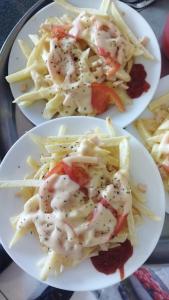 two plates of food with shrimp and french fries at HOSTAL EL AROMO pensión a empresas in Chillán