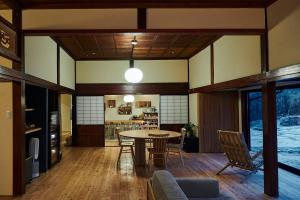 ein Wohnzimmer mit einem Tisch und Stühlen in der Unterkunft wine& stay Shinyashiki in Nishimura