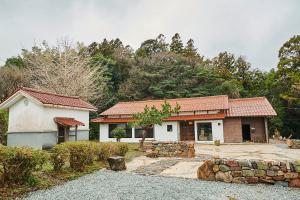 ein Haus mit einer Steinmauer neben einem Gebäude in der Unterkunft wine& stay Shinyashiki in Nishimura