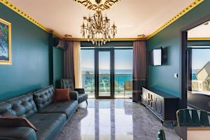 a living room with a couch and a chandelier at Apartments Beach Tower in Batumi