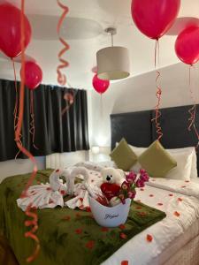 a bed with two stuffed animals and balloons on it at Canary Wharf Apartments in London