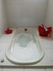 a bath tub filled with water in a bathroom at Sobrado com hidromassagem in Cabo Frio