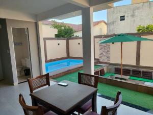 a dining room with a table and a swimming pool at Sobrado com hidromassagem in Cabo Frio